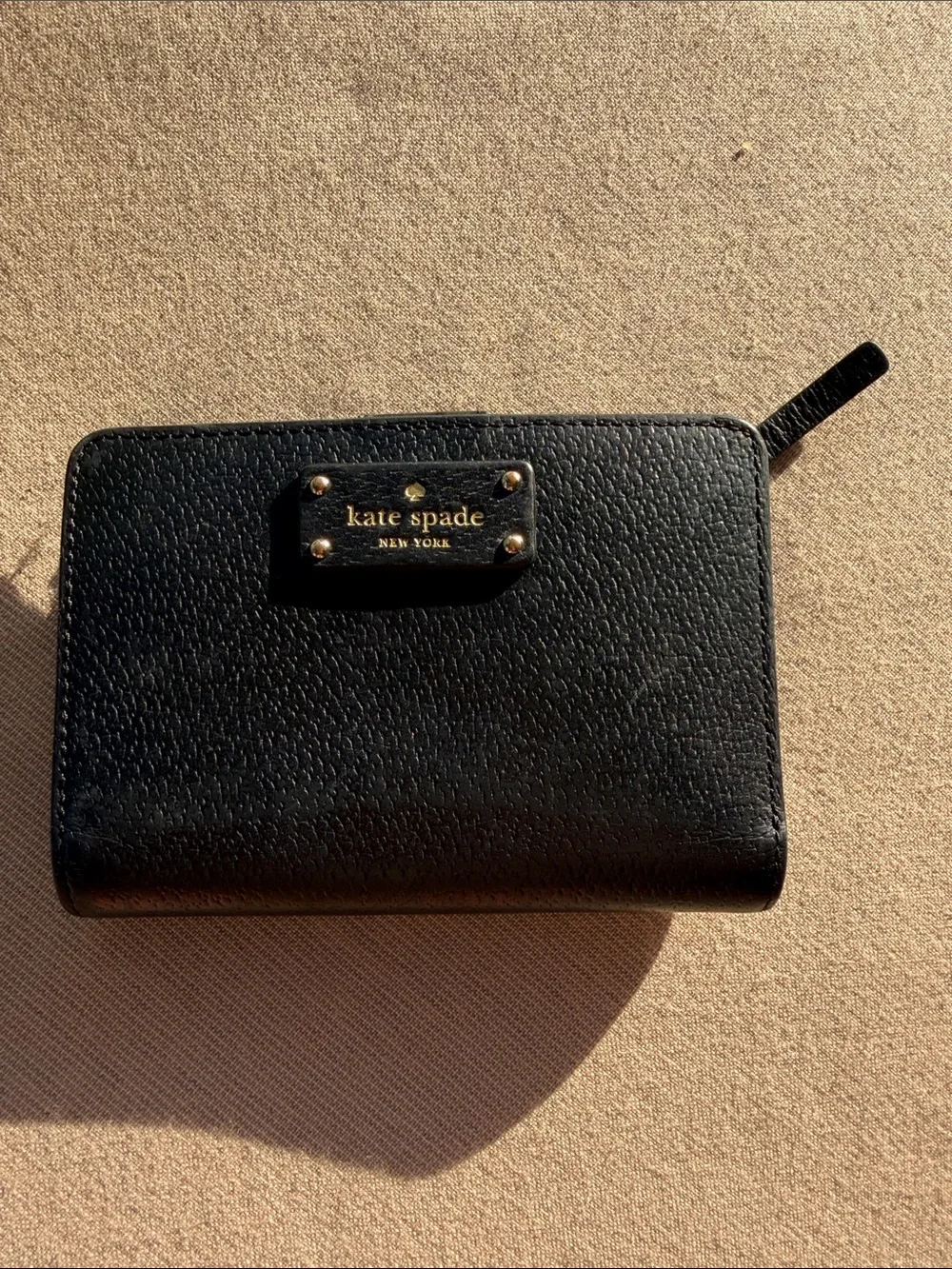 kate spade black pebble leather zip-around wallet with gold logo